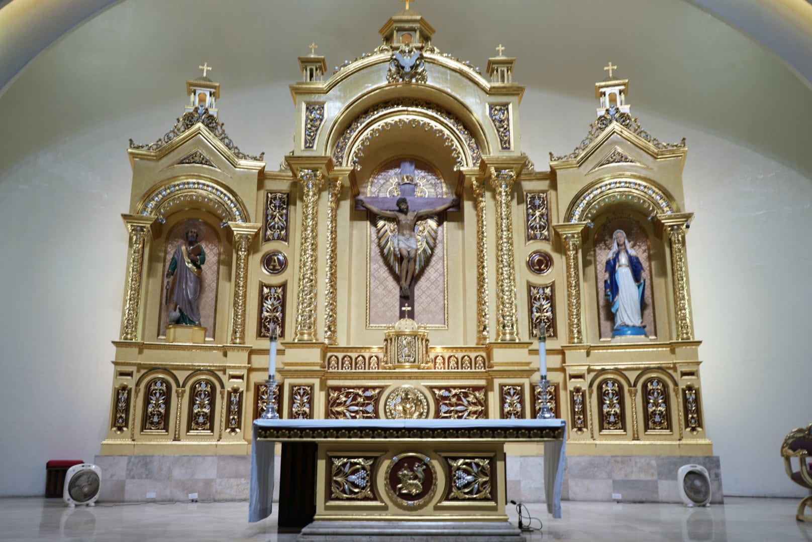The gilded main altar, with the image of Saint Peter in the left niche, the crucifix at the centre, and Our Lady on the right